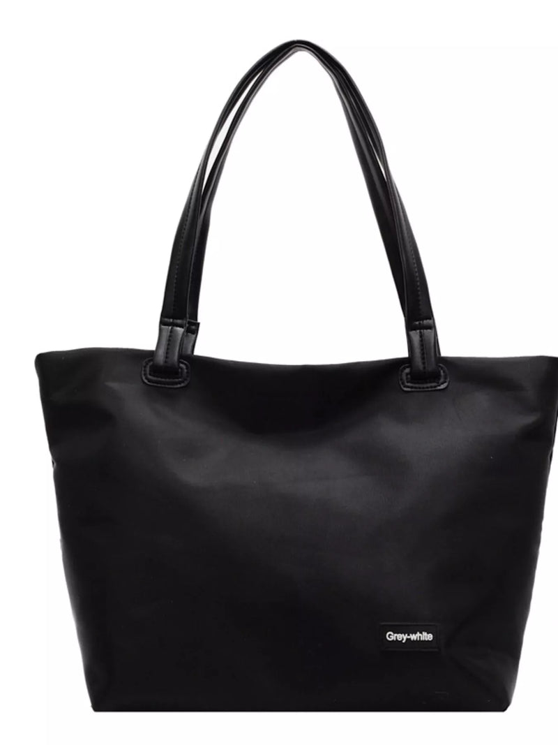 Black tote bag with a visible brand label on a white background