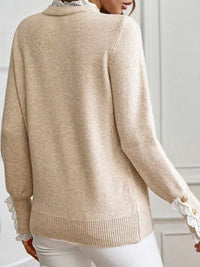 Beige sweater with lace details on cuffs and hem worn by a person.