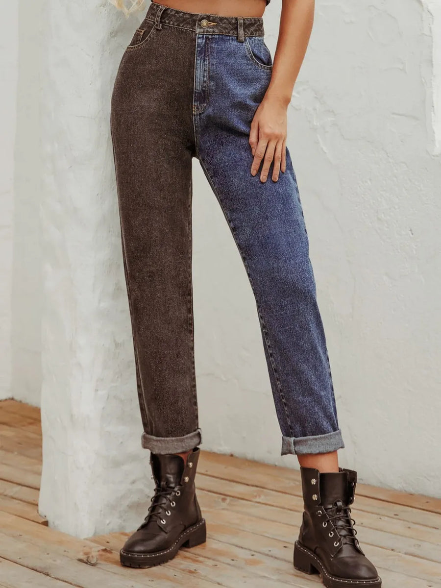 Person wearing a two-tone brown and blue jeans outfit with boots on a light wooden floor.