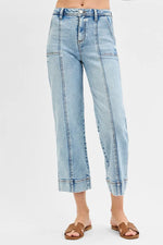 Light blue jeans worn by a person on a white background
