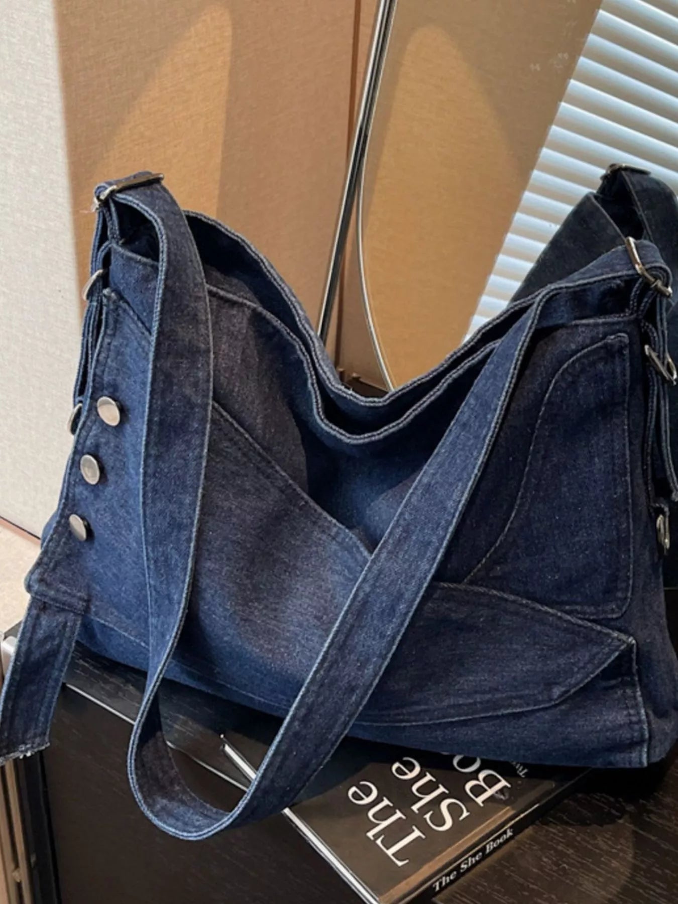 Blue denim handbag on a surface with a blurred background