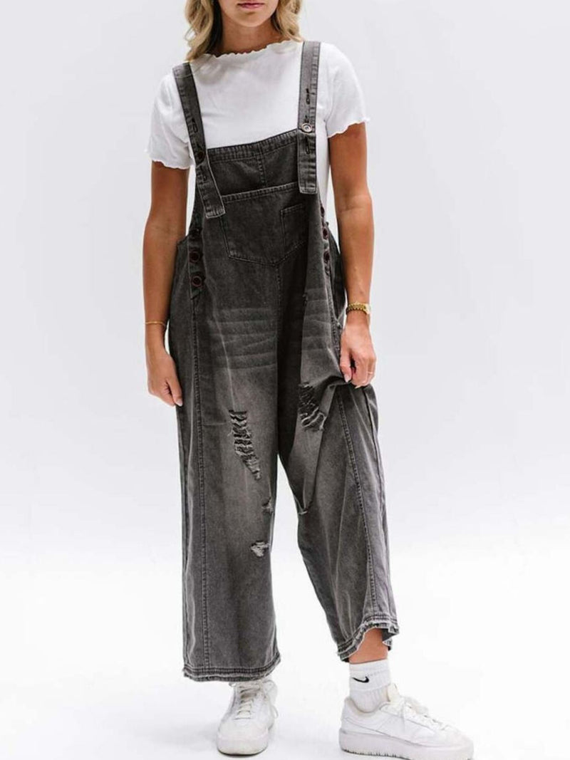 Person wearing gray distressed overalls on a white background