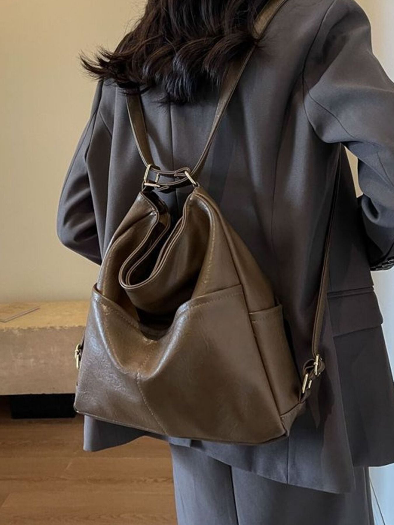 Person wearing a brown leather backpack indoors