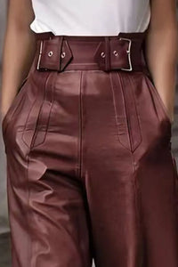 Brown leather pants with a belt worn by a person.