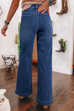 Person wearing blue jeans in a room with decor elements.