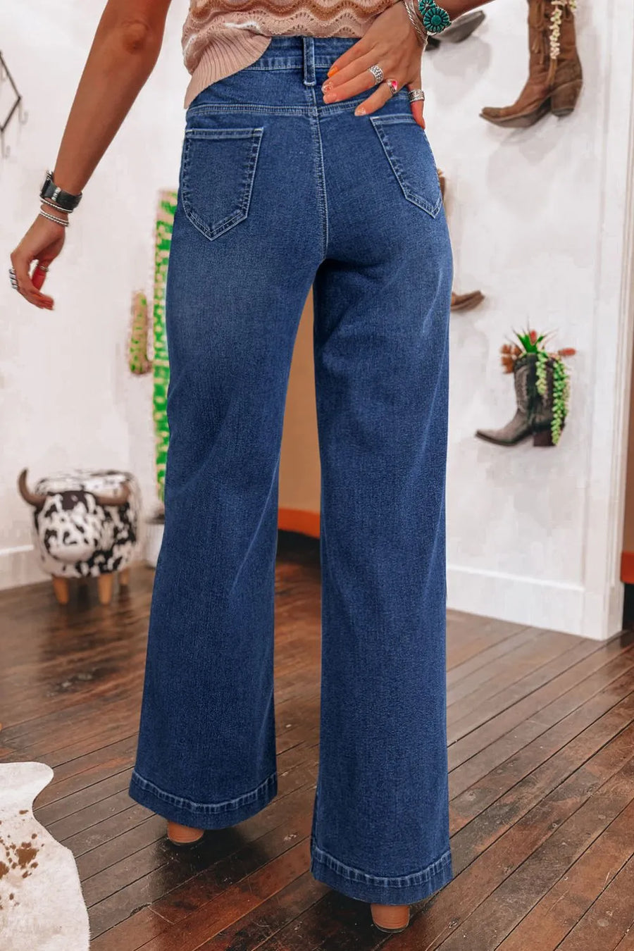 Person wearing blue jeans in a room with decor elements.
