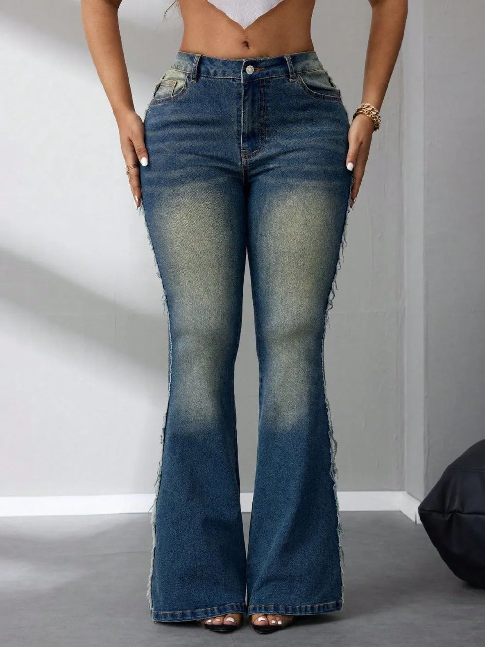 Person wearing high-waisted flared jeans on a plain background