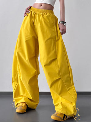 Person wearing bright yellow wide-leg pants on a plain background