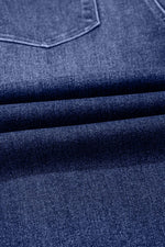 Close-up of blue denim fabric with a pocket detail
