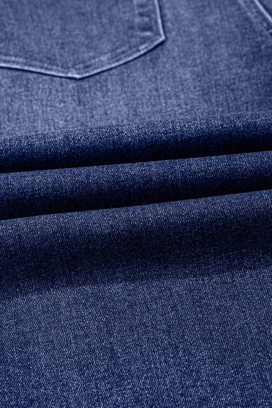 Close-up of blue denim fabric with a pocket detail