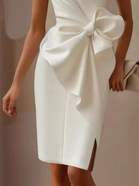 White dress with a large bow detail on a neutral background