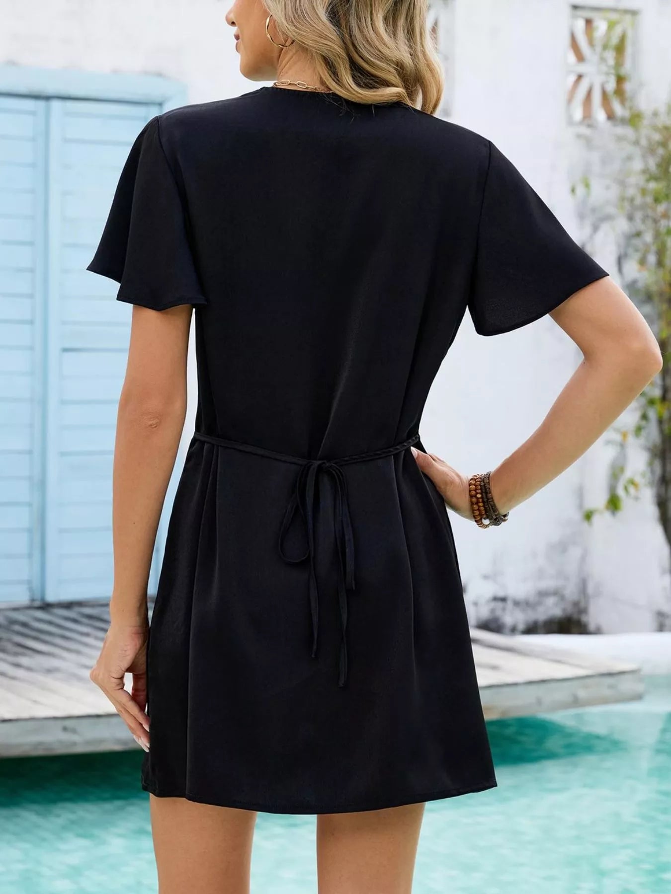 Woman wearing a black dress by a poolside