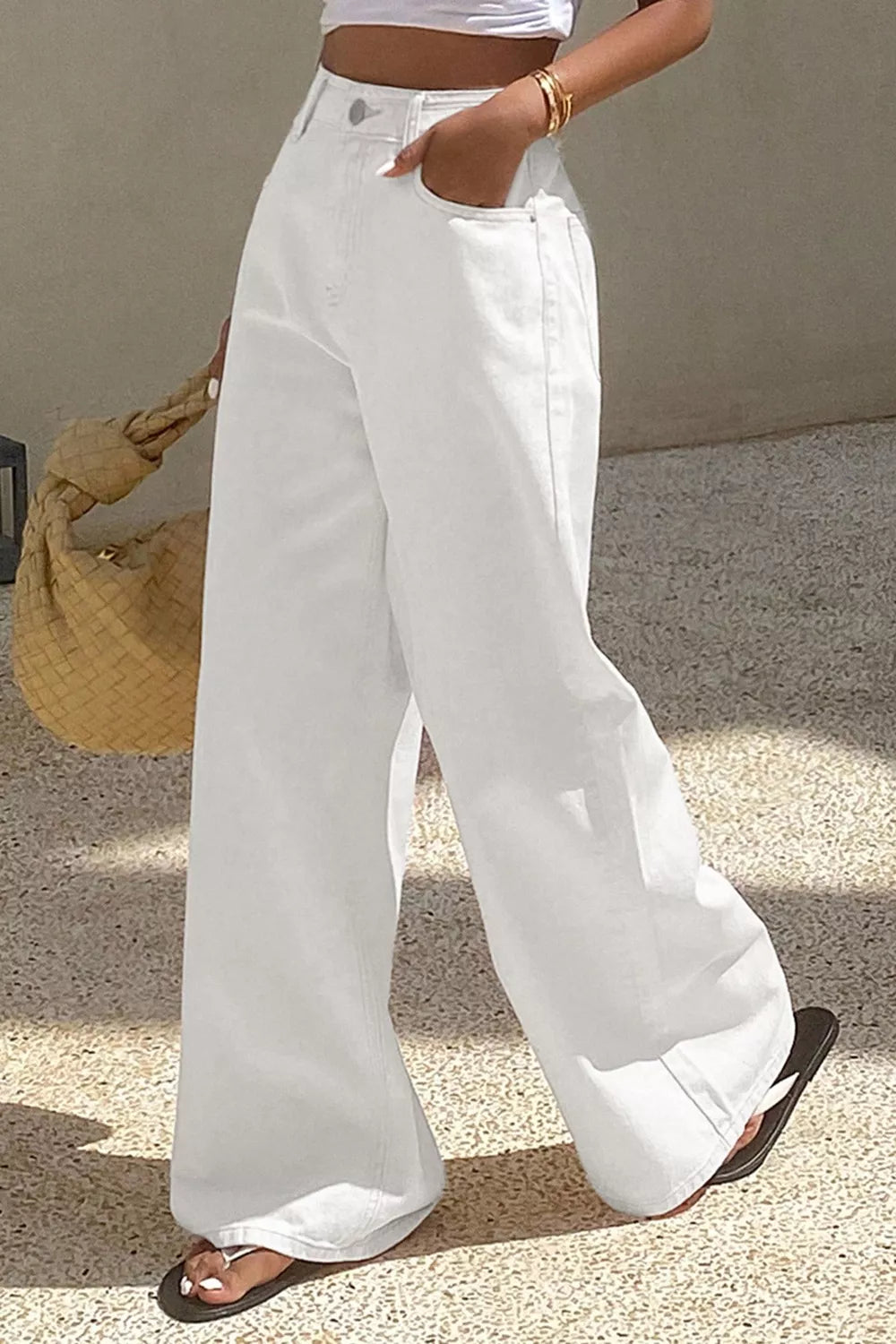 Person wearing white wide-leg pants with a neutral background