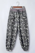 Gray camouflage pants on a hanger against a white background