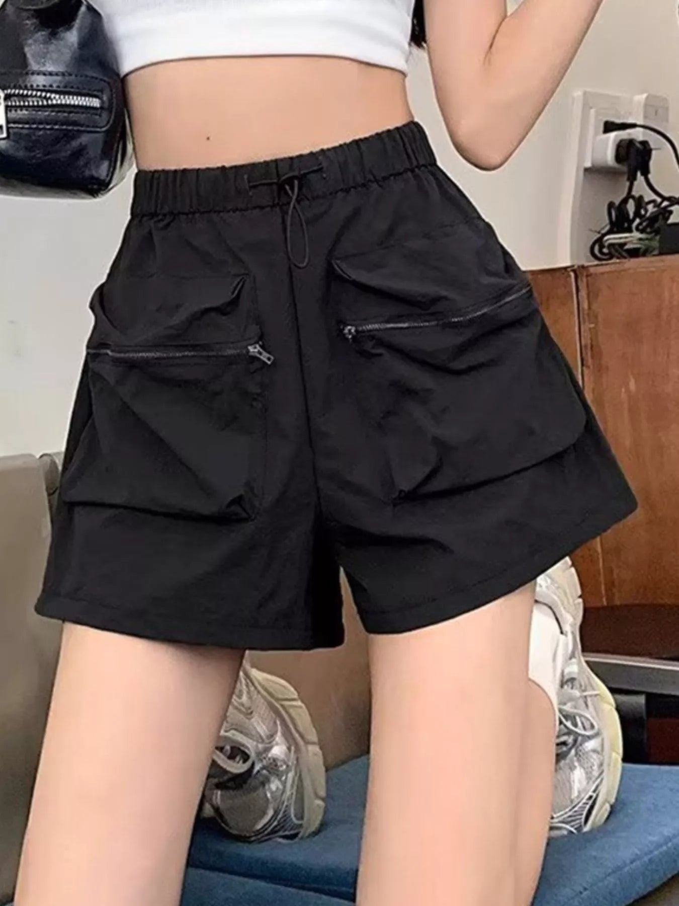 Person wearing black cargo shorts in an indoor setting