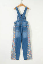 Blue denim overalls with floral patterns on a white background