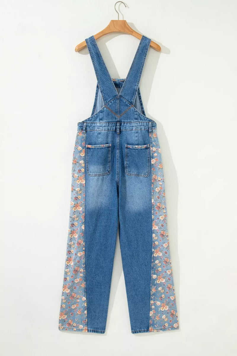 Blue denim overalls with floral patterns on a white background