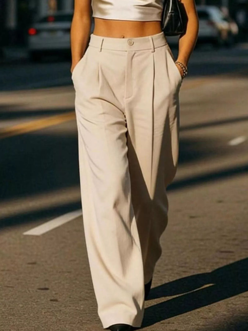 Person wearing beige high-waisted pants on a street.