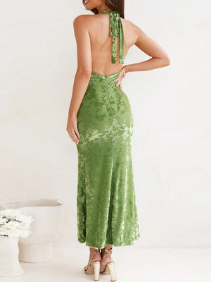 Green evening gown with open back worn by a person on a white background