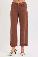 Brown jeans worn by a person on a white background