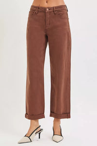 Brown jeans worn by a person on a white background