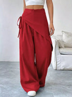 Red wide-leg pants worn by a person in a minimal indoor setting.