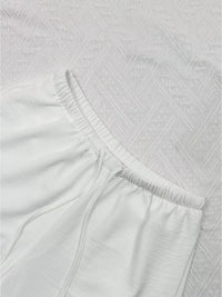 Close-up of textured white fabric with a subtle pattern