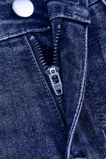 Close-up of a zipper on a blue denim jacket