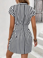 Black and white striped dress worn by a person on a white background