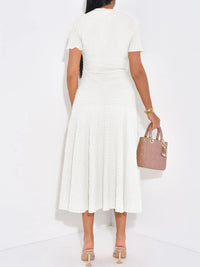 Woman wearing a white dress holding a pink handbag on a white background