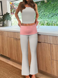 Person wearing a white top and light pink apron in a kitchen.