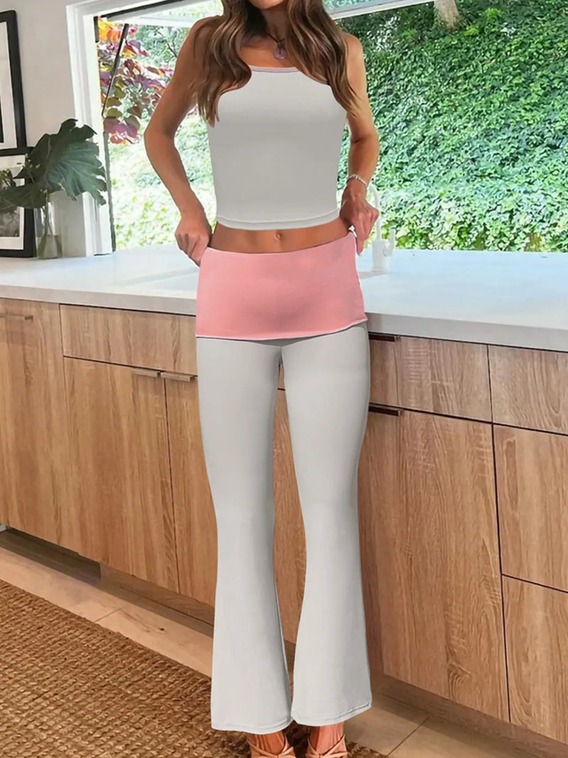 Person wearing a white top and light pink apron in a kitchen.