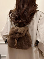 Person wearing a fur backpack with a neutral background