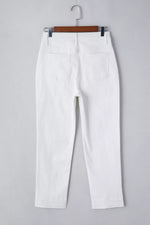 White pants on a hanger against a gray background