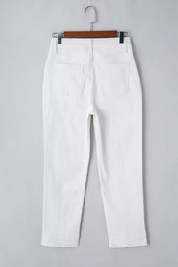 White pants on a hanger against a gray background