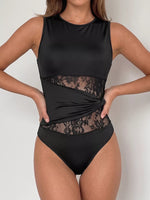 Black swimsuit with lace detailing on a plain background