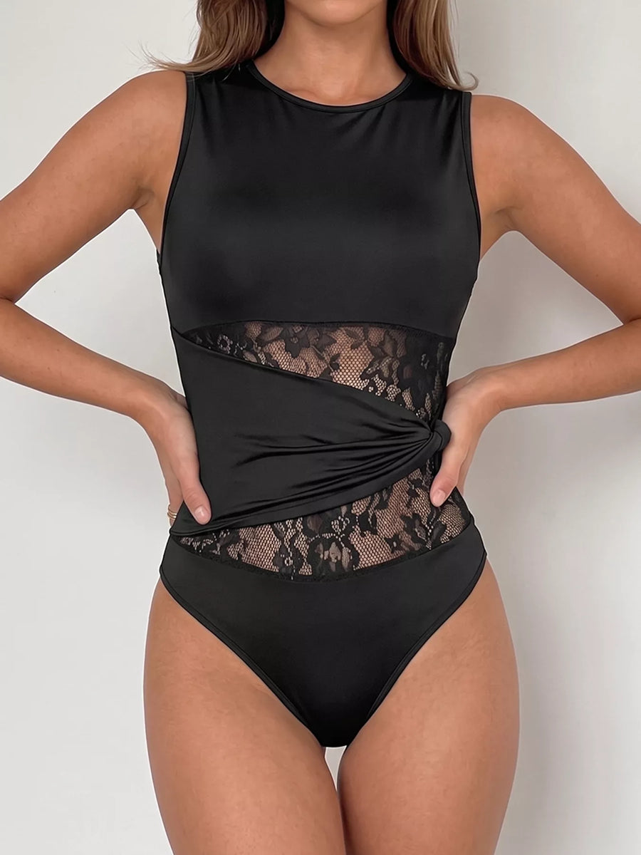 Black swimsuit with lace detailing on a plain background