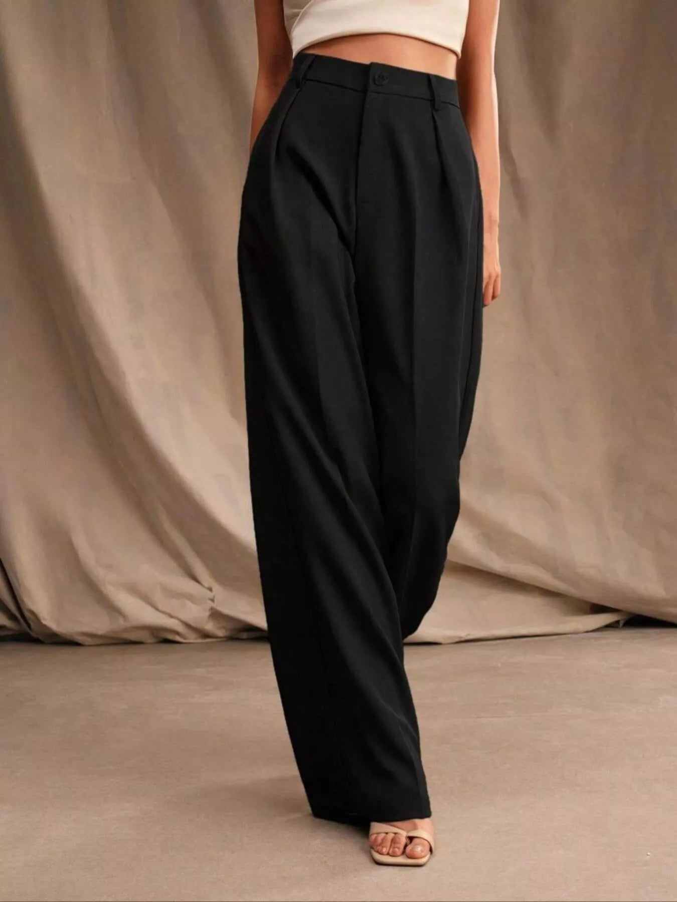 Black wide-leg pants worn by a person on a neutral background