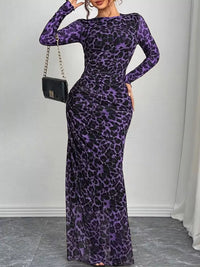 Woman wearing a purple leopard print dress against a white background