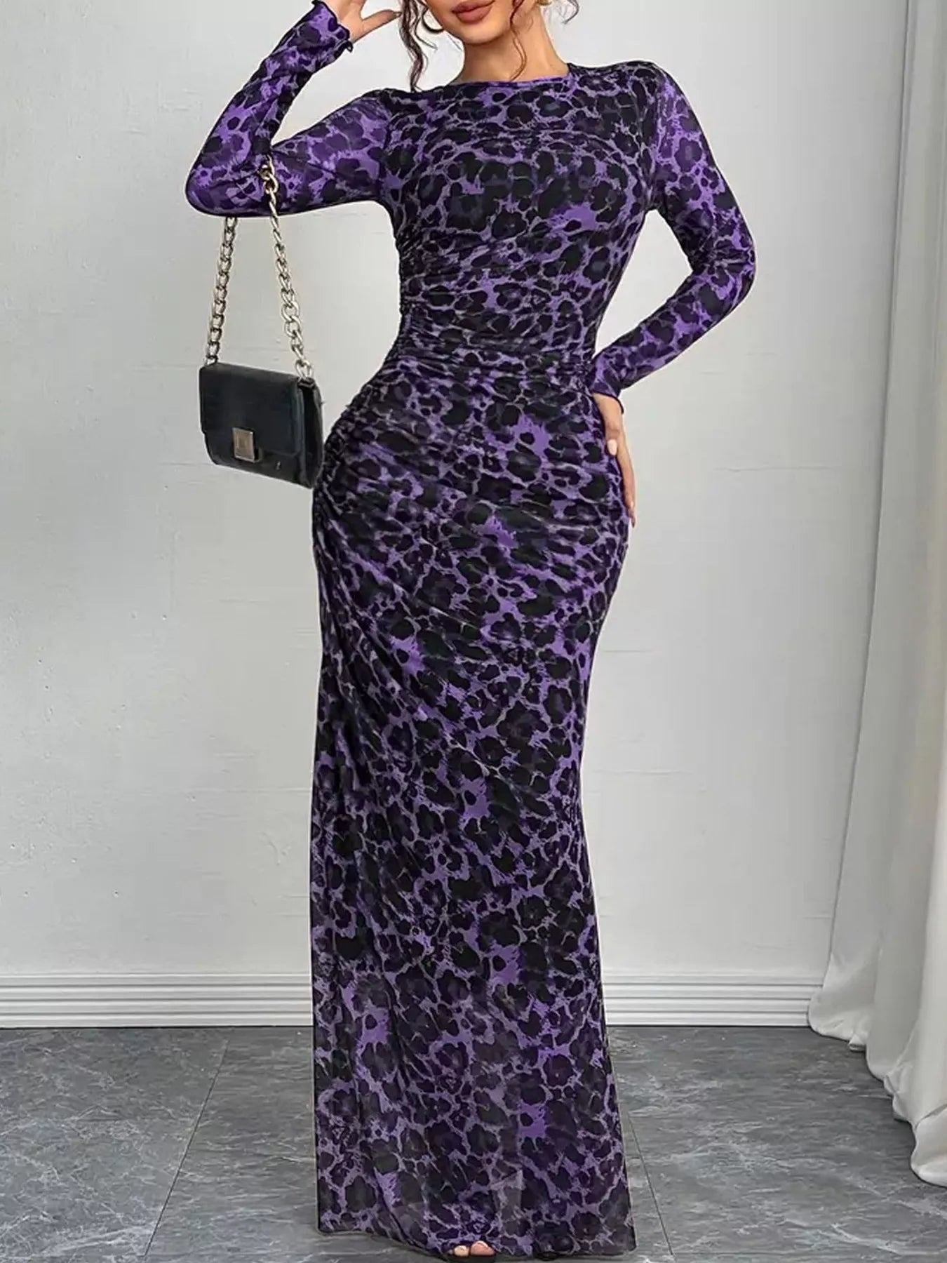 Woman wearing a purple leopard print dress against a white background