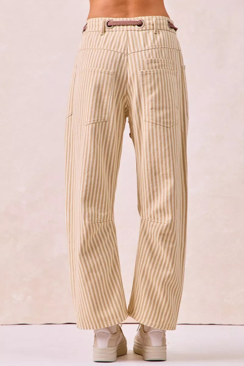 Beige striped pants worn by a person on a plain background