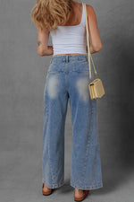 Person wearing a white tank top and blue jeans with a beige bag on a gray background