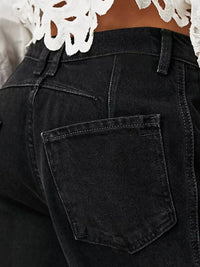Black jeans with a pocket detail, worn by a person.