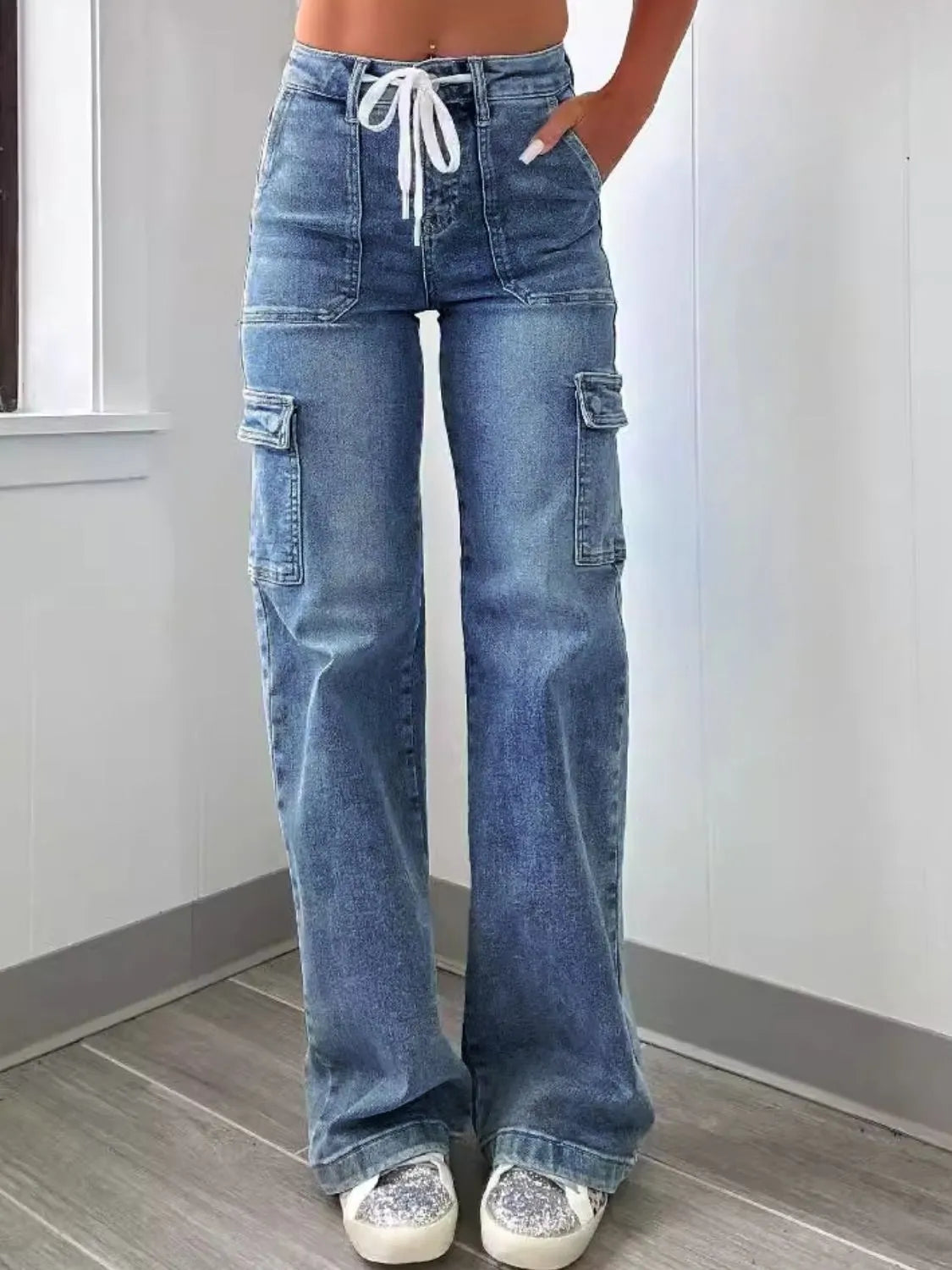 Person wearing blue cargo jeans with a white background