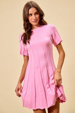 Woman wearing a pink dress against a beige background