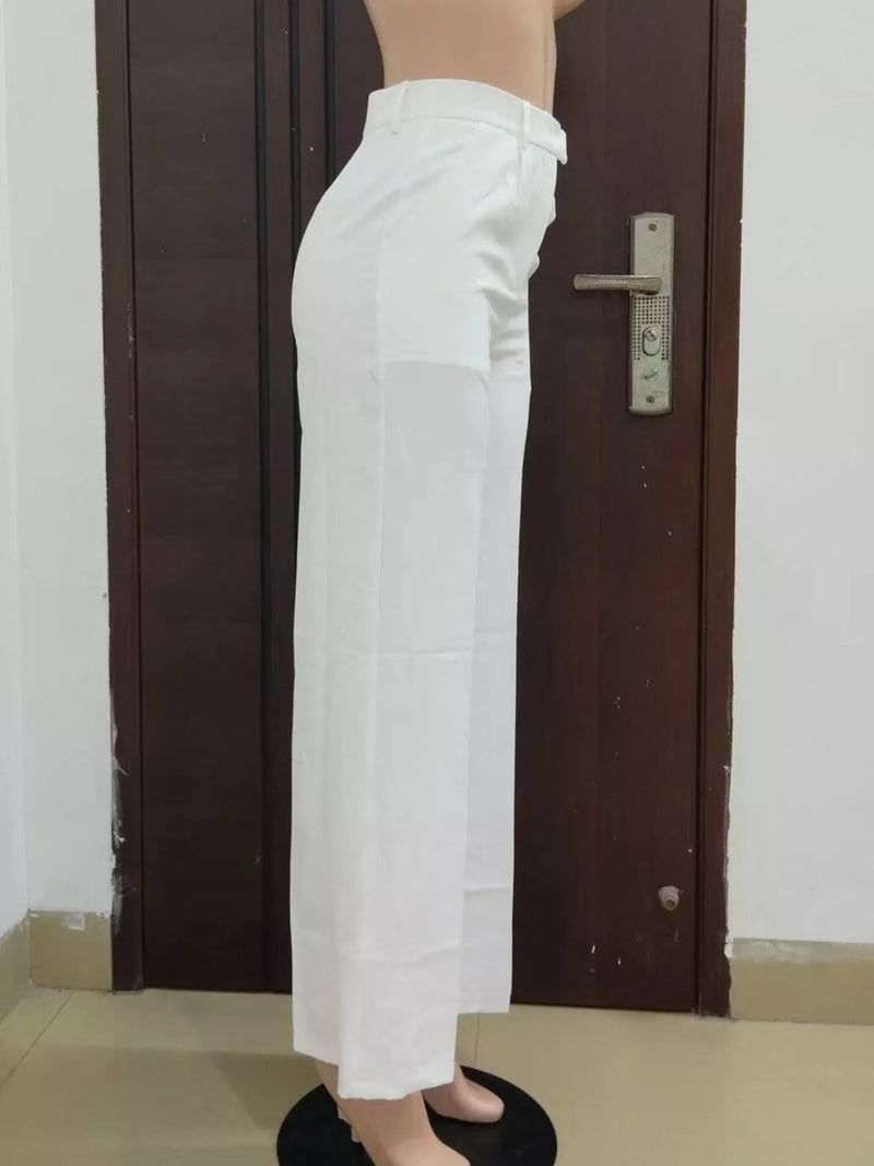 Person wearing white pants standing in front of a brown door.