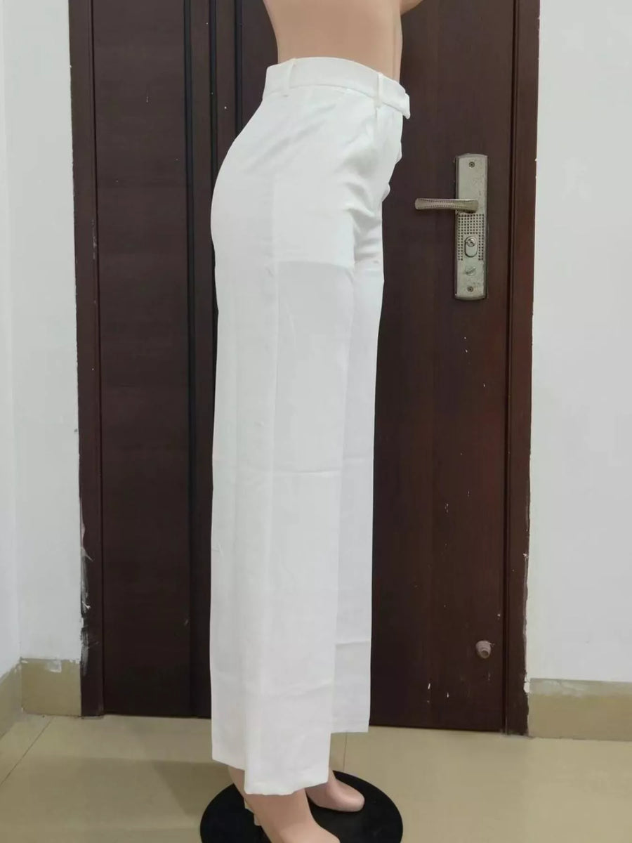 Person wearing white pants standing in front of a brown door.
