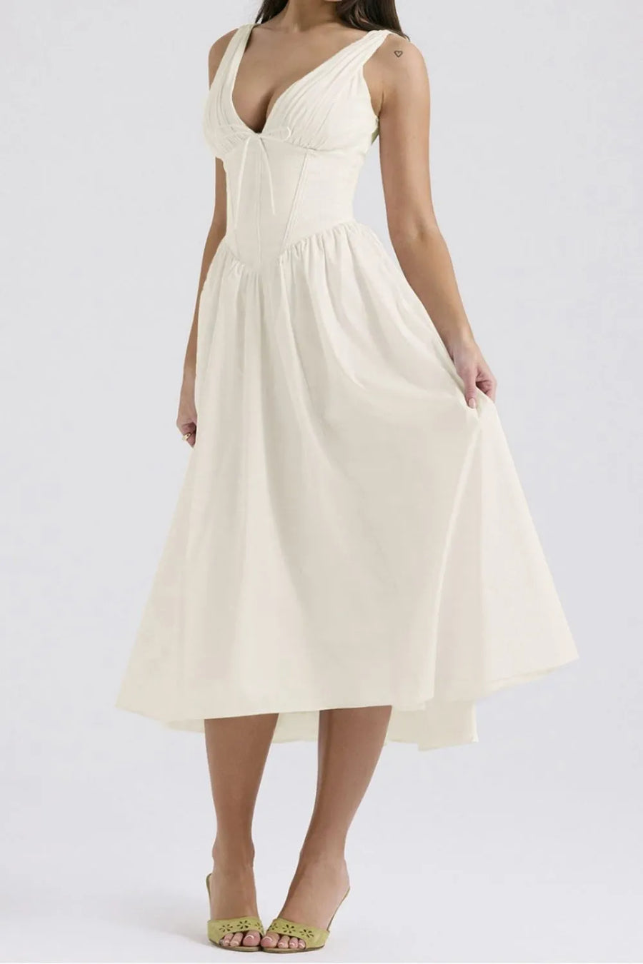 Woman wearing a white dress on a plain background