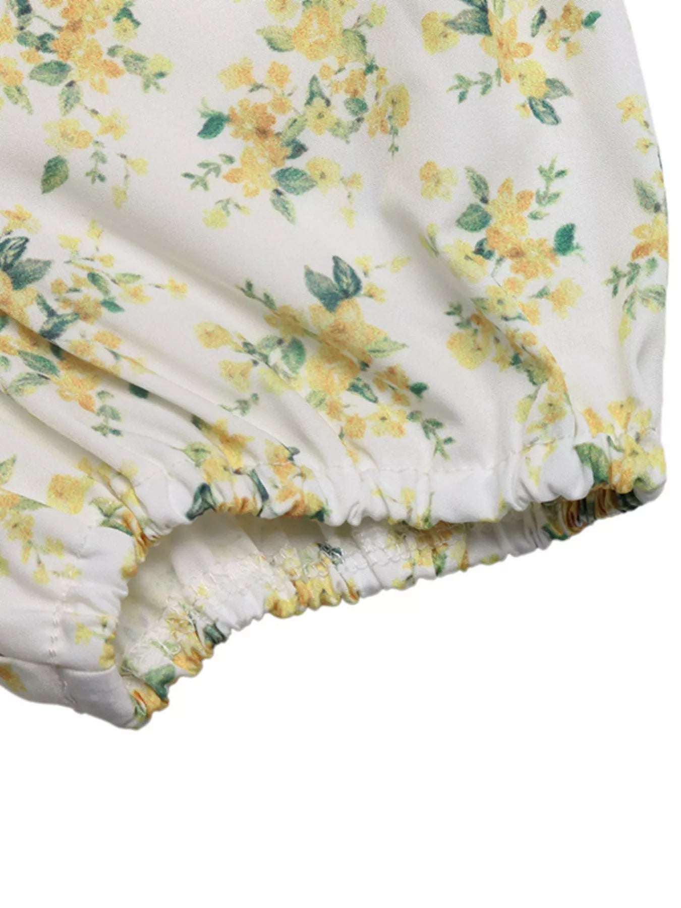 Floral patterned fabric with yellow flowers on a white background