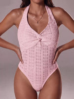 Pink lace one-piece swimsuit worn by a model on a neutral background